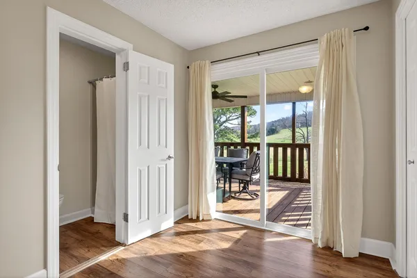 an empty room with wooden floor and windows