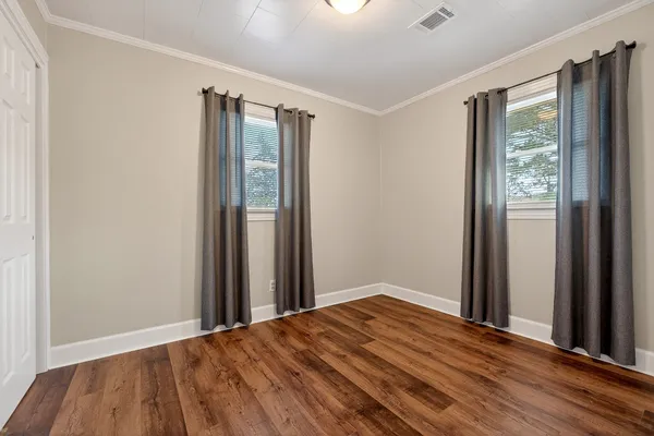 a view of a room with wooden floor and a window