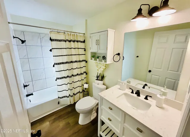 a bathroom with a sink toilet mirror and shower