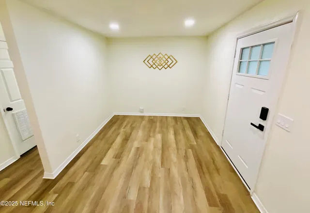 a view of a room with wooden floor and a ceiling fan