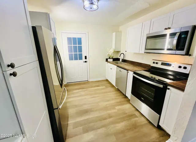 a kitchen with granite countertop a sink and cabinets