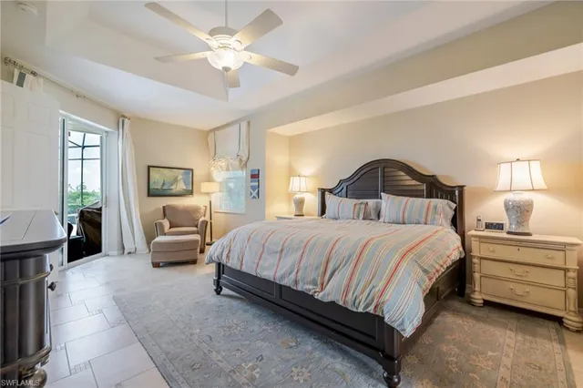 a bedroom with a bed a chandelier and a couch