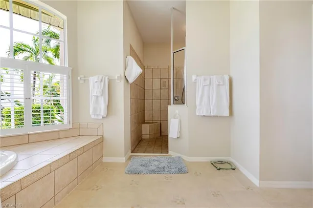 a bathroom with a tub shower and window