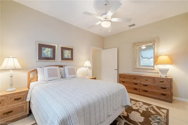 a bedroom with a bed and a lamp on dresser