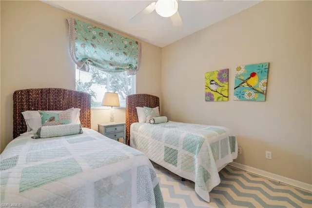 a bedroom with two beds and painting on the wall