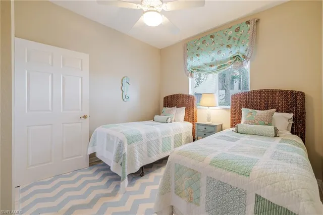 a bedroom with two beds and a chandelier