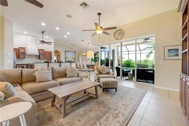 a living room with furniture a chandelier and a large window