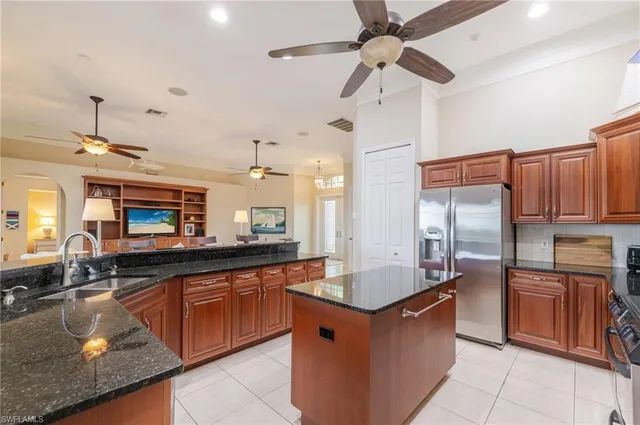a large kitchen with stainless steel appliances granite countertop a sink counter space cabinets and a counter top space