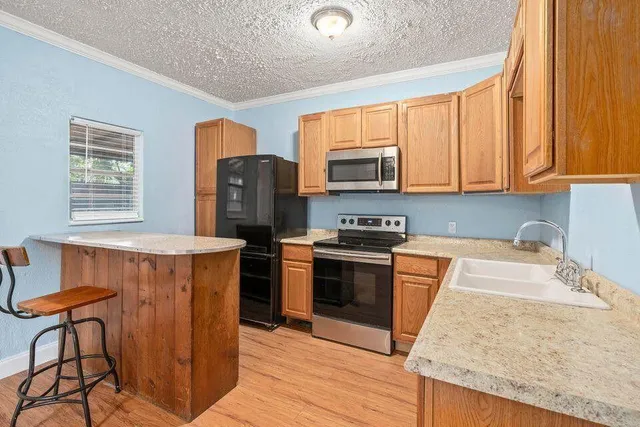 a kitchen with stainless steel appliances granite countertop a stove a sink dishwasher and a refrigerator
