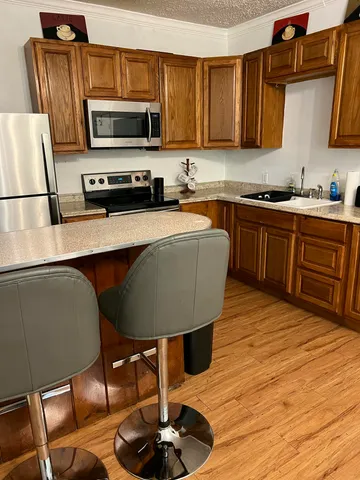 a kitchen with stainless steel appliances a stove a sink cabinets and a dining table