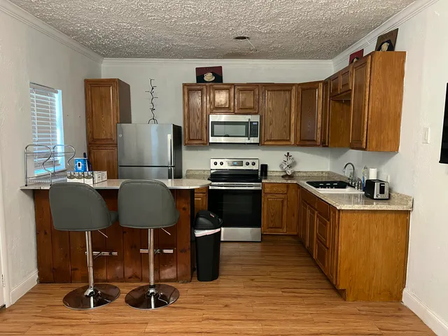 a kitchen with a sink cabinets and wooden floor