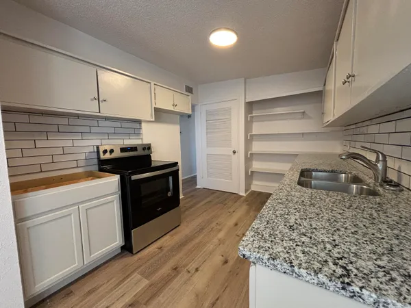 a kitchen with a sink and a stove top oven