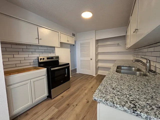 a kitchen with a sink and a stove top oven
