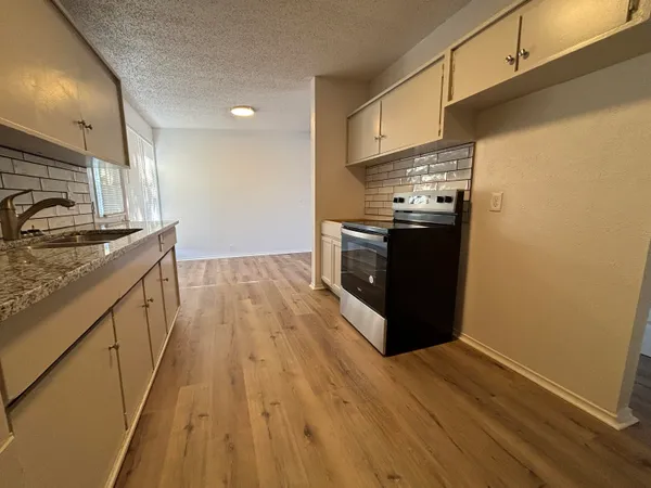 a kitchen with stainless steel appliances granite countertop a stove a sink and a refrigerator