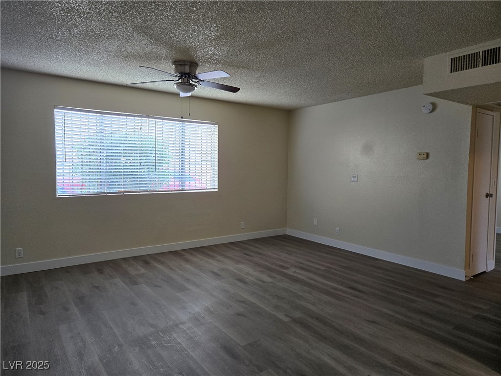 218 East Merlayne Drive, Unit 1 Henderson, NV 89011 - Photo 3 of 11 Spare room featuring dark wood-type flooring, a textured ceiling, and ceiling fan