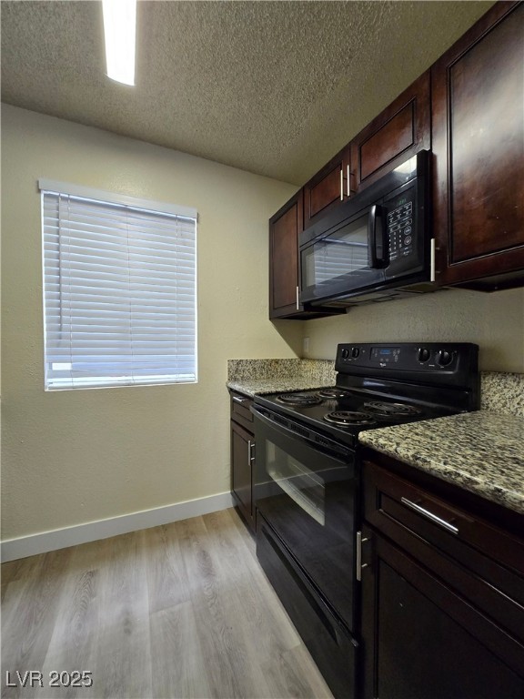 218 East Merlayne Drive, Unit 1 Henderson, NV 89011 - Photo 7 of 11 Kitchen with black appliances, a textured ceiling, light wood-style floors, dark brown cabinets, and light stone counters