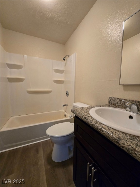 218 East Merlayne Drive, Unit 1 Henderson, NV 89011 - Photo 9 of 11 Full bathroom featuring a textured ceiling, vanity, wood finished floors, and washtub / shower combination