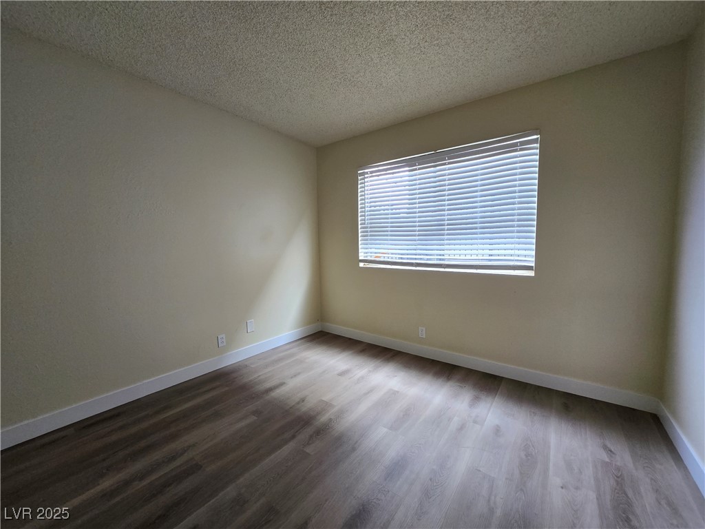 218 East Merlayne Drive, Unit 1 Henderson, NV 89011 - Photo 10 of 11 Unfurnished room featuring a textured ceiling and dark wood-style floors