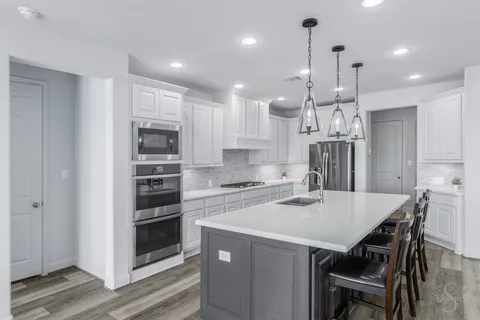 a spacious bathroom with a granite countertop tub sink a mirror a shower and vanity