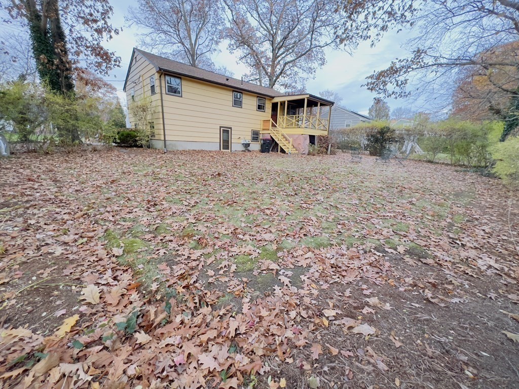 40 Michael Drive Brockton, MA 02301 - Photo 6 of 22 a backyard of a house with large trees and brick wall