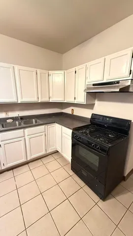 a white stove top oven sitting inside of a kitchen