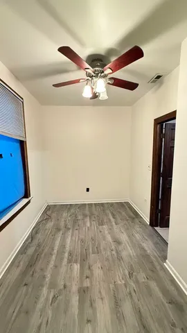 a view of a room with wooden floor and ceiling fan