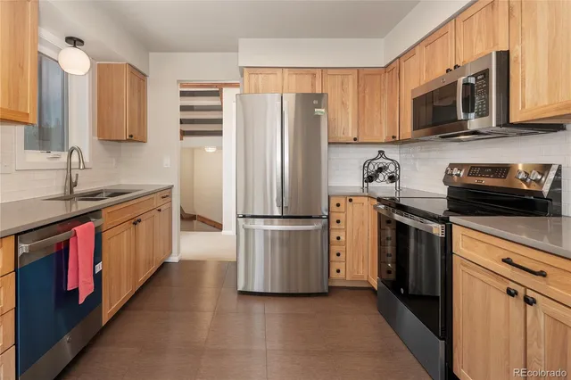 a kitchen with stainless steel appliances granite countertop a refrigerator sink and cabinets