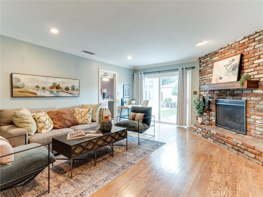 6138 Freckles Road Lakewood, CA 90713 - Photo 1 of 1 a living room with furniture a large window and a fireplace
