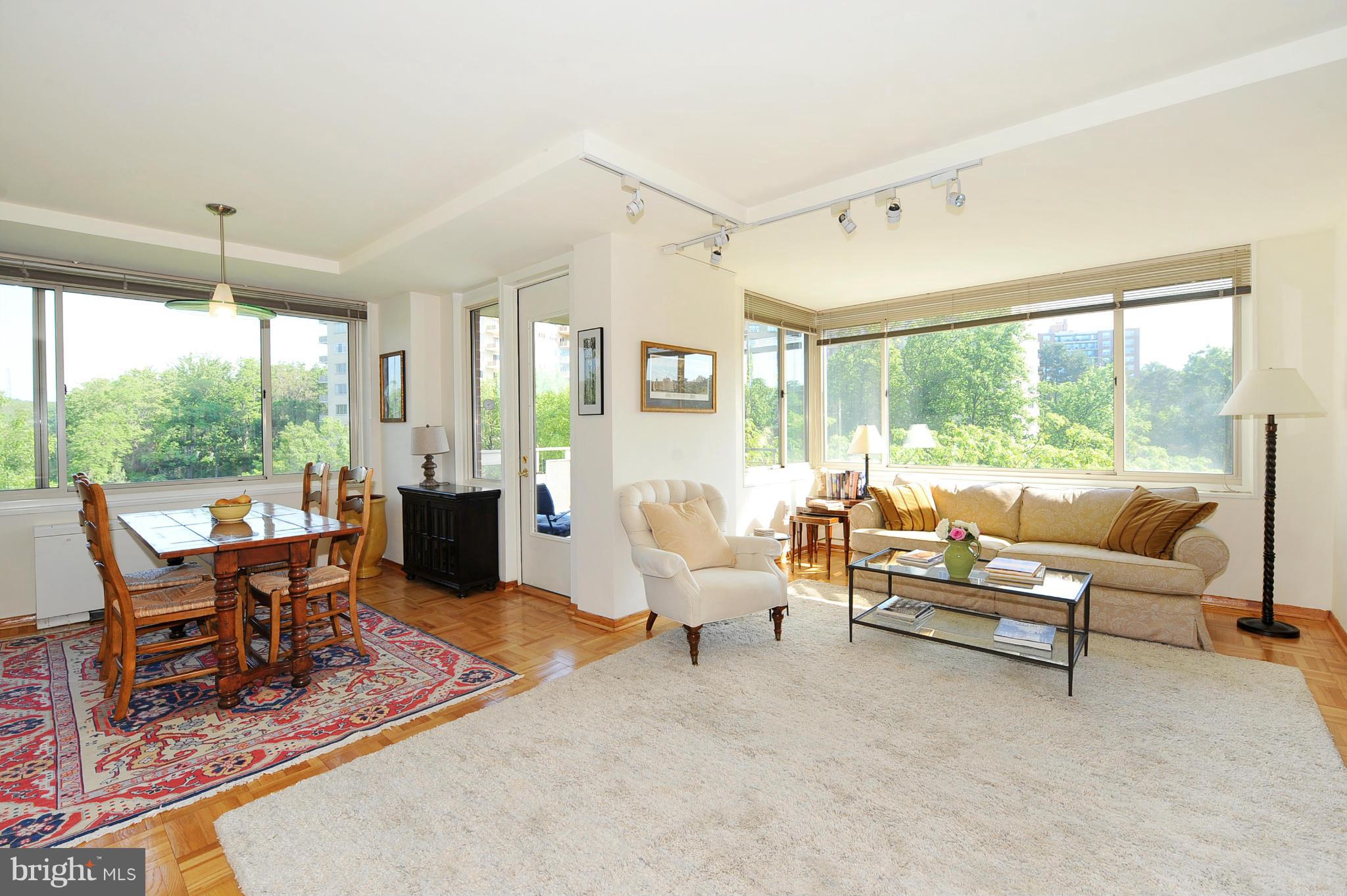 4000 Tunlaw Road Northwest, Unit 1026 Washington, DC 20007 - Photo 5 of 15 a living room with furniture large windows and wooden floor