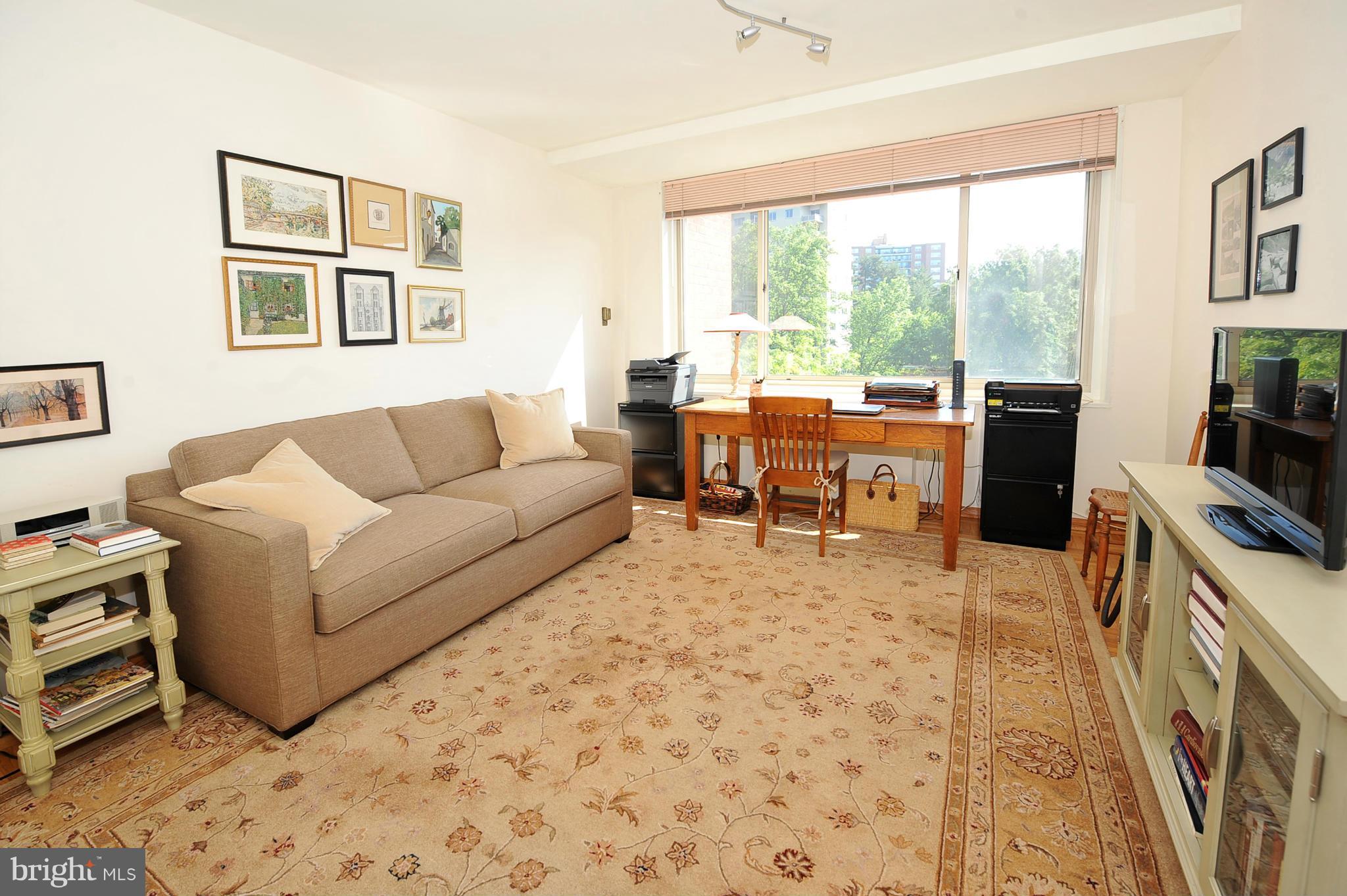 4000 Tunlaw Road Northwest, Unit 1026 Washington, DC 20007 - Photo 9 of 15 a living room with furniture a large window and a flat screen tv