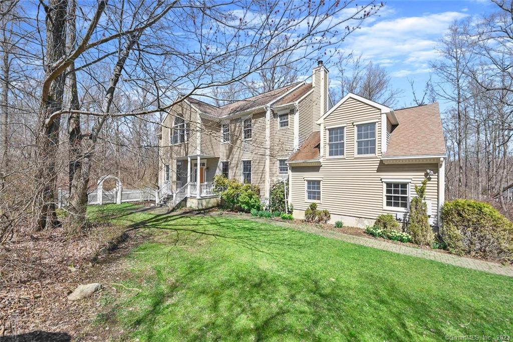 a view of a yard in front of a house with large windows
