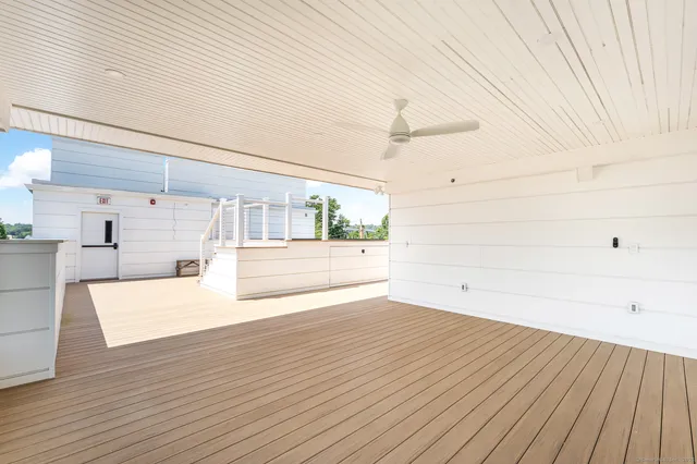 a view of a room with wooden floor and electronic appliances