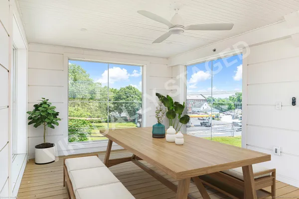 a dining room with furniture potted plants and wooden floor