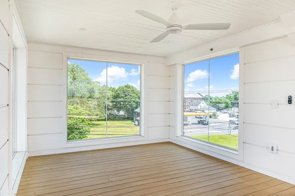 a view of an empty room with a window and wooden floor