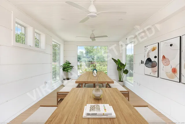 a large white room with a large window and potted plants