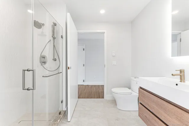 a bathroom with a sink a toilet and shower