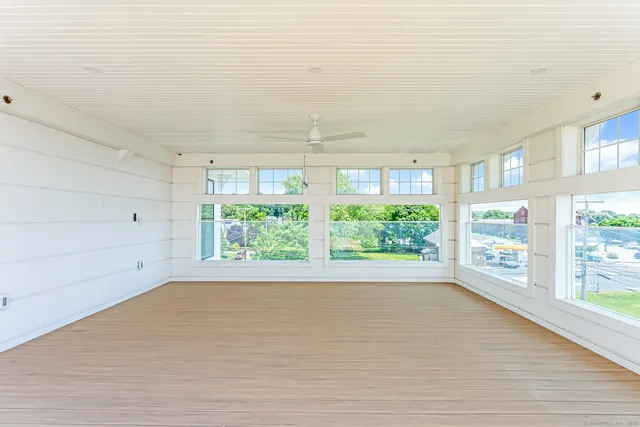 a view of a big room with wooden floor and windows