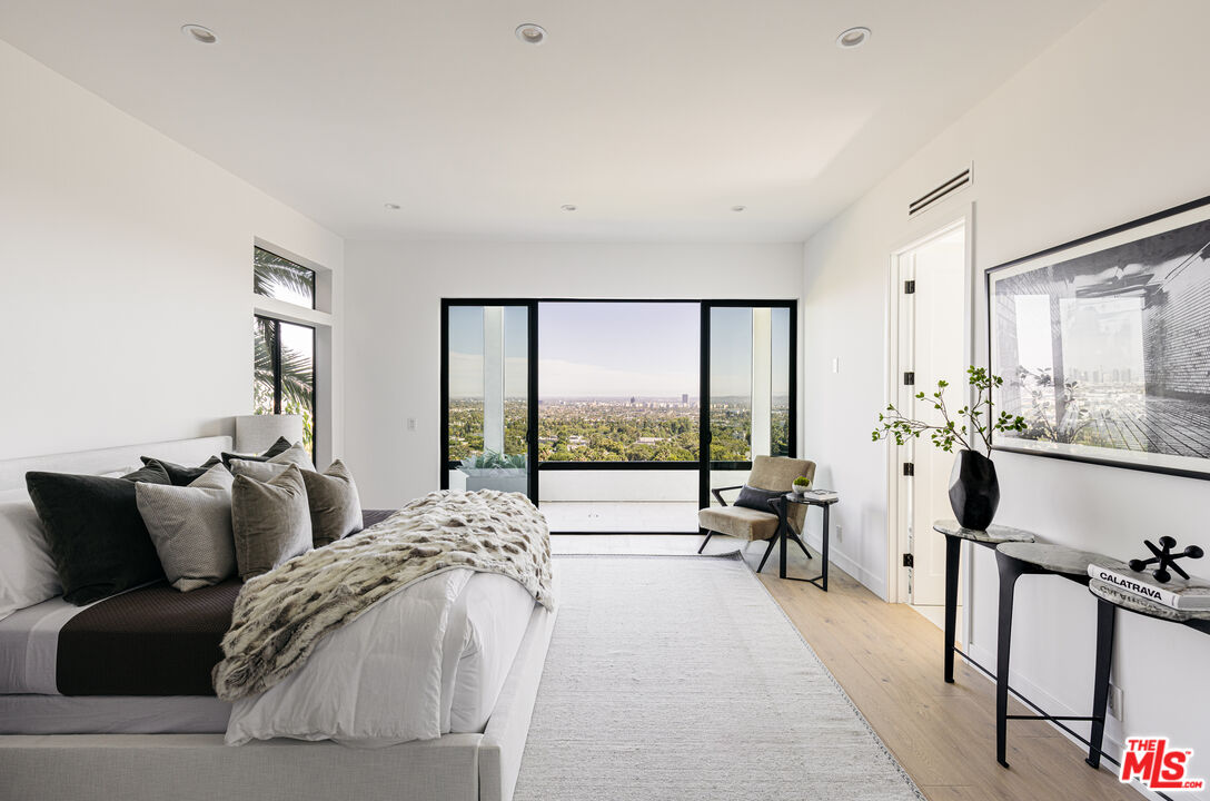7866 Fareholm Drive Los Angeles, CA 90046 - Photo 10 of 27 a large bedroom with a bed and large windows