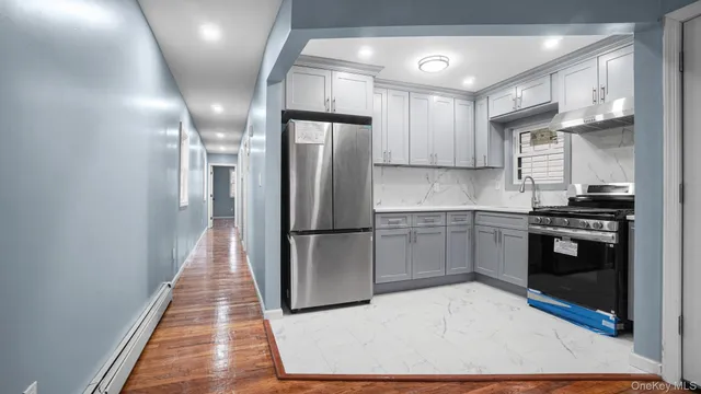 a kitchen with stainless steel appliances a refrigerator and a stove top oven