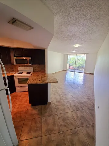 a kitchen with stainless steel appliances a stove a sink and a refrigerator