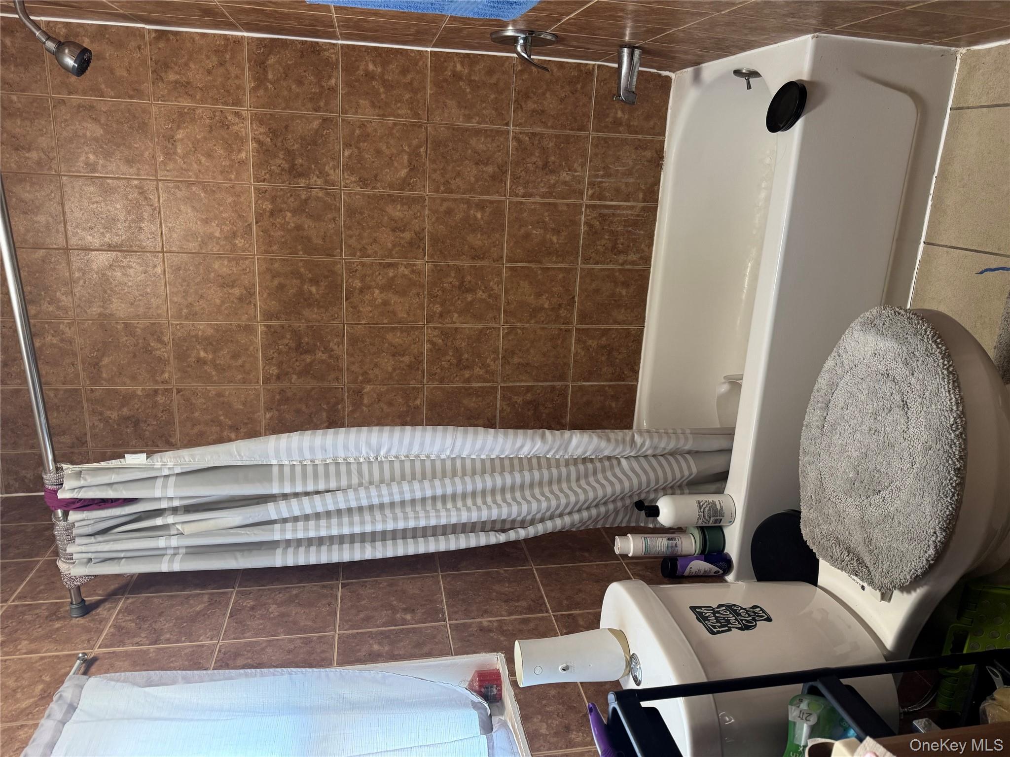 94-13 116th Street Queens, NY 11419 - Photo 17 of 34 Full bathroom featuring shower / tub combo, tile patterned floors, and tile walls