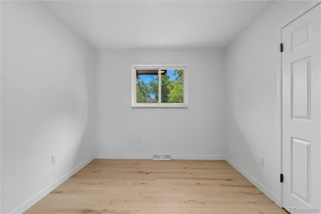 wooden floor in an empty room with a window
