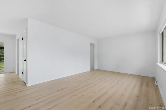 a view of an empty room with wooden floor
