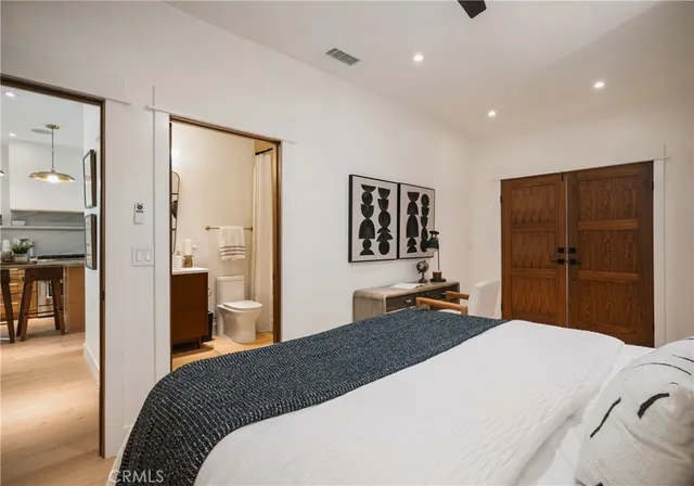 a bedroom with a bed a mirror and a dresser