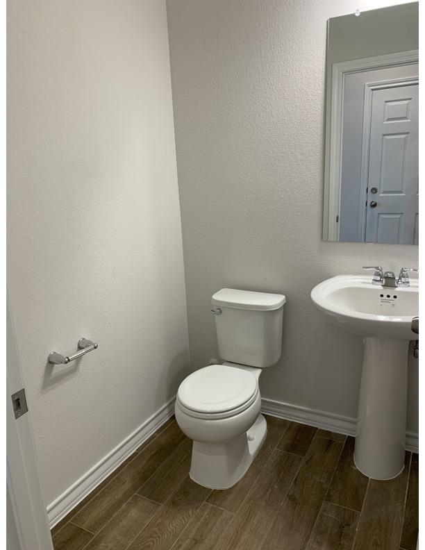 11715 Caithness Way Austin, TX 78653 - Photo 14 of 40 Half bathroom downstairs with wood tiled floors and a textured wall