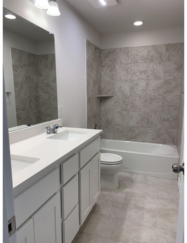 11715 Caithness Way Austin, TX 78653 - Photo 24 of 40 Bathroom featuring double vanity, bathing tub / shower combination, and recessed lighting