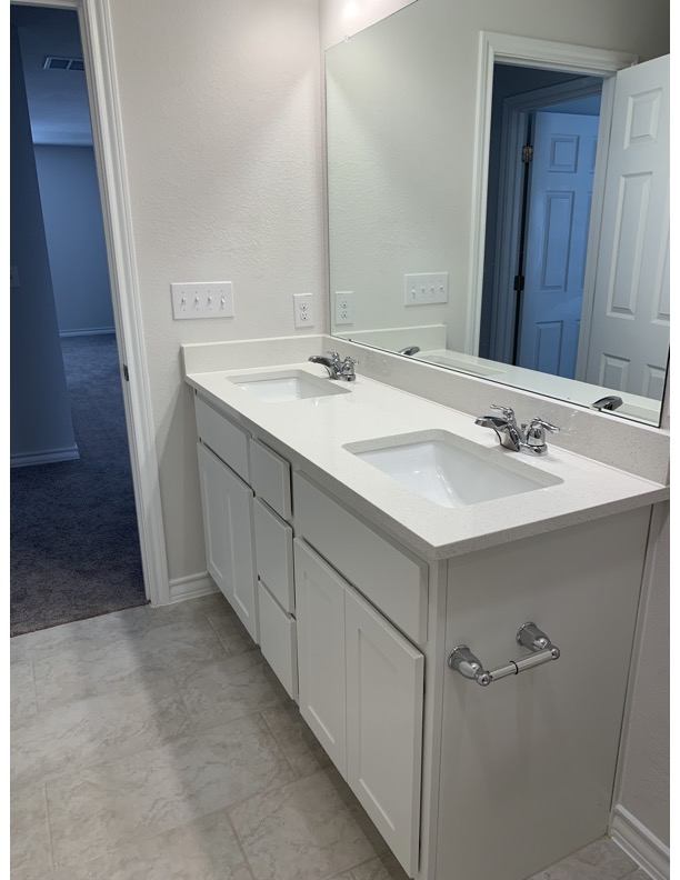 11715 Caithness Way Austin, TX 78653 - Photo 25 of 40 Bathroom featuring double vanity and baseboards