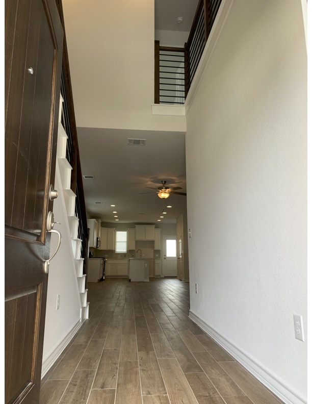 11715 Caithness Way Austin, TX 78653 - Photo 3 of 40 Entryway featuring wood finished tile floors, a high ceiling, and a ceiling fan