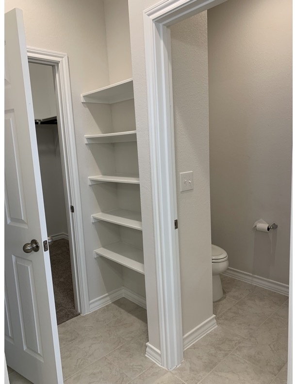 11715 Caithness Way Austin, TX 78653 - Photo 33 of 40 Primary bathroom featuring baseboards and a walk in closet