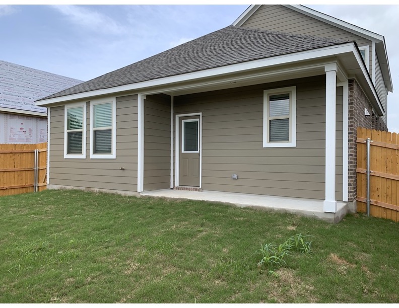 11715 Caithness Way Austin, TX 78653 - Photo 38 of 40 Back of house featuring a shingled roof and a covered patio